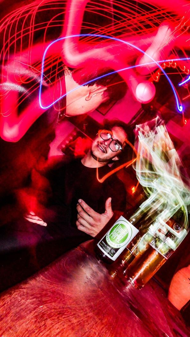 Clientes disfrutando cerveza y música entre luces rojas en El Nido